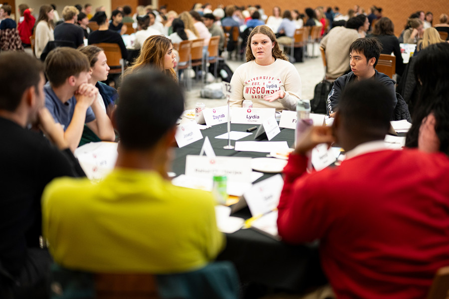 Large groups of people sitting around tables, talking